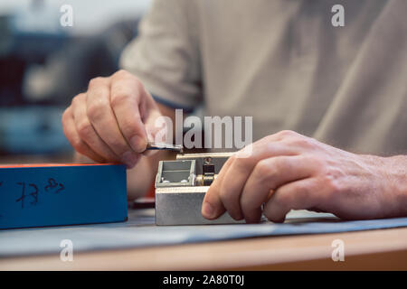 Lockmith lavorando su una serratura la riparazione di esso Foto Stock