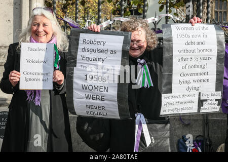 Londra, 05 novembre 2019. Le donne dal 'WASPI' (Donne contro la pensione statale di disuguaglianza) campagna, molti in variopinti costumi suffragette, protesta contro quello che percepiscono per essere sleali in termini della loro pensione statale e il modo in cui lo stato dell'età di pensionamento per gli uomini e per le donne è stata eguagliata. Lo stand del gruppo in una catena di solidarietà lungo le Case del Parlamento e poi bloccare una strada sulla piazza del Parlamento a gridare circa la loro causa. Credito: Imageplotter/Alamy Live News Foto Stock