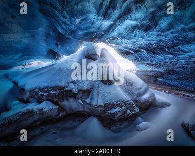 Grotta di ghiaccio nel ghiacciaio Vatnajokull, Islanda in inverno. Neve all'interno. Soffitto di cristal blu ghiaccio. Foto Stock