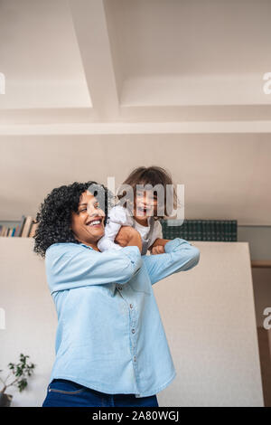 La madre che porta la sua piccola figlia sulla sua spalla Foto Stock