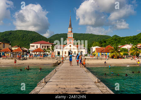 Martinica, Francia - 19 August 2019: Petite Anse d'Arlet village, con San Henri Chiesa e pontoon. Foto Stock