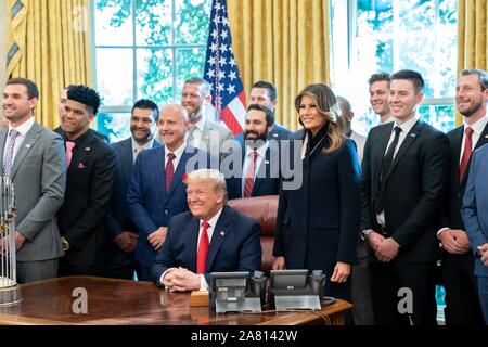 Washington, Stati Uniti d'America. 04 Novembre, 2019. Stati Uniti Presidente Donald Trump e la First Lady Melania Trump posano con membri del Washington cittadini World Series champs durante una celebrazione della vittoria nell'Ufficio Ovale della Casa Bianca il 4 novembre 2019 a Washington, DC. Credito: Shealah Central Plaza Hotel/White House foto/Alamy Live News Foto Stock