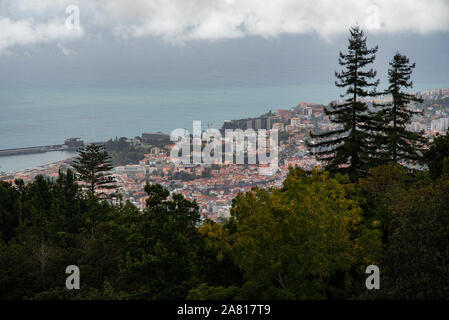Vista panoramica della città di Funchal con i suoi caratteristici tetti di tegole rosse. La capitale di Madeira, in Portogallo, circondata da colline e dall'Oceano Atlantico Foto Stock