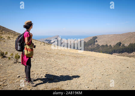 Turista femminile godendo di una splendida vista sulla comunità Challa nel lato settentrionale dell'isola del sole, il lago Titicaca, Bolivia Foto Stock