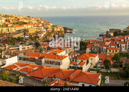 Vista panoramica su Câmara de Lobos, Madeira, Portogallo, con tetti di tegole rosse che scendono verso l'Oceano Atlantico Foto Stock