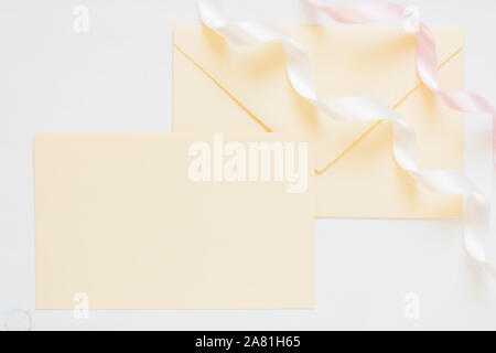 Blank color crema busta con nastri, mock up per romantiche inviti, design di nozze Foto Stock