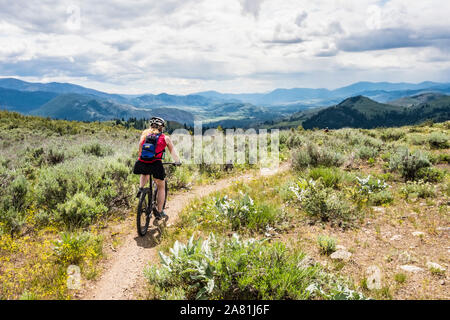 Una donna mountain bike su una porzione del Monte Saraceno Loop Trail fuori Winthrop, Washington, Stati Uniti d'America. Foto Stock