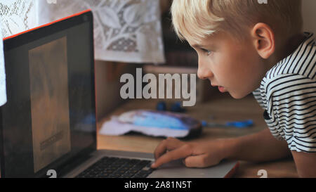 I bambini sono a sfogliare le foto su un computer portatile. Foto Stock