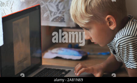 I bambini sono a sfogliare le foto su un computer portatile. Foto Stock