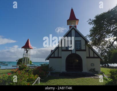 Cap Malheureux Chiesa cattolica in Mauritius con laguna blu in background e vegetazione in primo piano Foto Stock