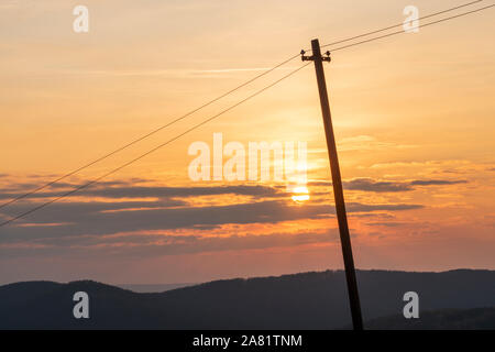 In legno antico elettricità o polo di telecomunicazioni al tramonto. Carpazi orientali, Slovacchia, Europa Foto Stock