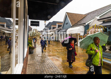 Il Villaggio di Bicester outlet, Inghilterra , gli acquirenti su un umido la pioggia di giorno in aprile 04 2019 nel Regno Unito. Foto Stock