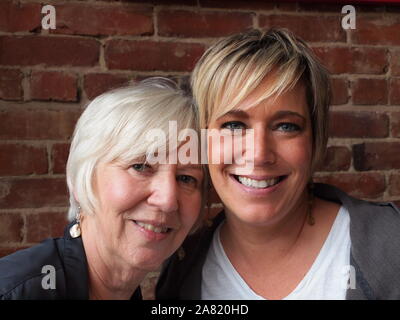 Madre e figlia sorridente alla fotocamera. Foto Stock