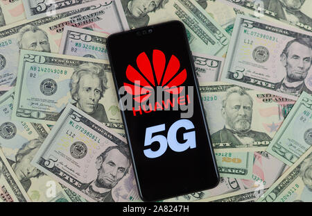 Huawei logo sullo smartphone che viene posto in dollari USA. Foto concettuale per Huawei profitti fuori i loro 5G reti. Foto Stock