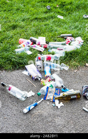 Cucciolata ambientale o rifiuti gettati a terra. Bottiglie di vetro lattine di lattina di sacchetti di plastica di bottiglie in plastica e carta Foto Stock