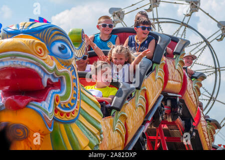 Battle Creek Michigan STATI UNITI D'AMERICA LUGLIO 4, 2019; bambini felici ridere come loro cavalcata su un roller coaster presso il campo volo di evento Foto Stock
