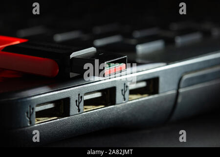 Unità flash nella porta USB del computer notebook in tenebre. Concetto di progresso tecnologico nel computer i dati dei sistemi di registrazione. Foto Stock