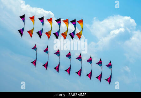 Colorato stunt kites soar in un nuvoloso cielo blu durante un kite festival in Grand Haven MI USA Foto Stock