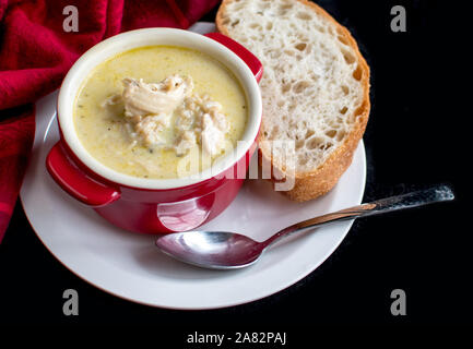 Crema di Pollo e riso minestra con pezzi di petto di pollo e una fetta di pane fragrante Foto Stock