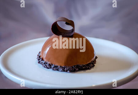 Delizioso cioccolato torta del mouse con un ricciolo di cioccolato, su una piastra di ceramica Foto Stock