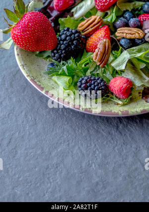 Deliziosa insalata fresca ,con bacche blu, nero bacche Fragole, verdi e le noci pecan Foto Stock