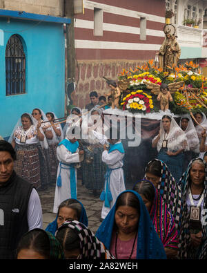 Giovani chierichetti swing bruciatori di incenso nella processione cattolica della Vergine del Carmen in San Pedro La Laguna, Guatemala. Le donne nella tradizionale può Foto Stock