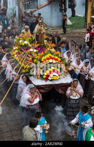 Giovani chierichetti swing bruciatori di incenso nella processione cattolica della Vergine del Carmen in San Pedro La Laguna, Guatemala. Le donne nella tradizionale può Foto Stock