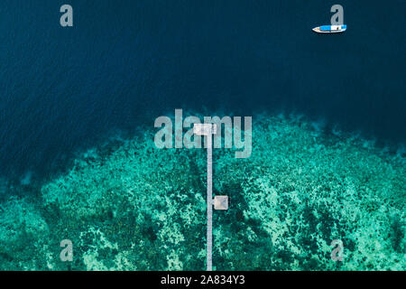 Antenna vista astratta di barche in legno pier sull isola tropicale con barriera corallina e turchesi acque cristalline. Concetto di vacanza. Foto Stock
