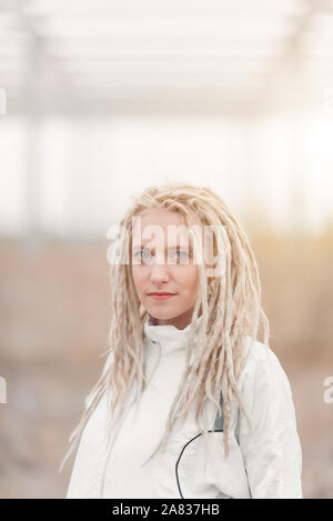 Giovane donna in abiti bianchi con dreadlocks ritratto di acconciatura Foto Stock