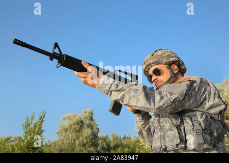 Soldato in camuffamento prendendo mirano all'aperto Foto Stock