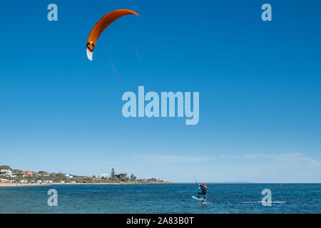 MELBOURNE, Australia - 31 August, 2019: Kite surfer si innalza al di sopra dell'acqua essendo tirato da vela Foto Stock