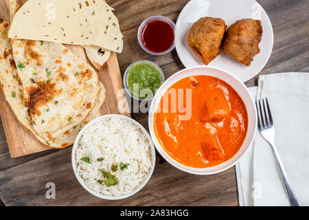 Il cibo indiano con pollo tikka masala, samosas, riso, Naan e papadum, sulla vista di testa Foto Stock