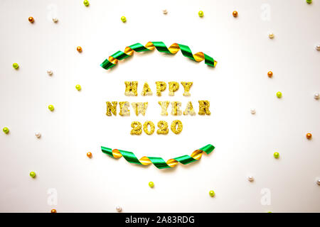 Semplice felice anno nuovo 2020 Testo in oro scritte, Nastro arricciato e perline colorate isolati su sfondo bianco - Celebrazione e concetto di vacanze Foto Stock