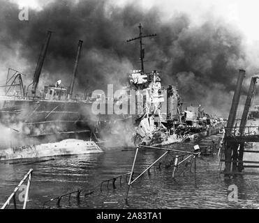 Fotografia navale di documentare l'attacco giapponese a Pearl Harbor, Hawaii che ha avviato la partecipazione degli Stati Uniti nella seconda guerra mondiale. La marina della didascalia: il ritorto rimane del cacciatorpediniere USS SHAW la masterizzazione in floating drydock a Pearl Harbor Foto Stock