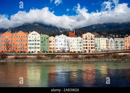 Case colorate sul fiume Inn con neve montagne dietro, Innsbruck, in Tirolo, Austria Foto Stock