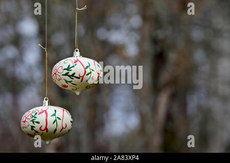 Due palle di Natale appeso all'aperto nella foresta su una giornata autunnale Foto Stock