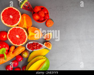 Fresh rosso, arancione, giallo di frutta e verdura ricca di antiossidanti e di fibre, alfa carotene, licopene, beta-carotene, carotenoide, luteina, fosforo Foto Stock