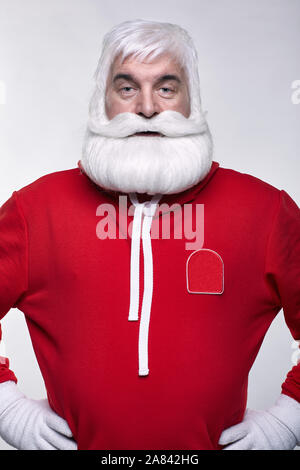 Ritratto di una Santa Claus in sportsware. Bianco-dai capelli uomo anziano con barba e baffi cercando nella fotocamera. Foto Stock