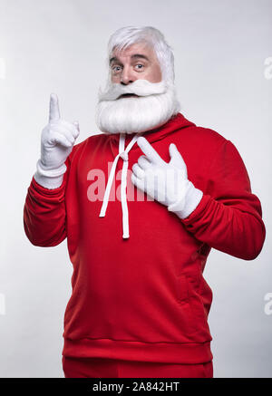 Ritratto di una Santa Claus in sportsware. Bianco-dai capelli uomo anziano con barba e baffi cercando nella fotocamera. Foto Stock