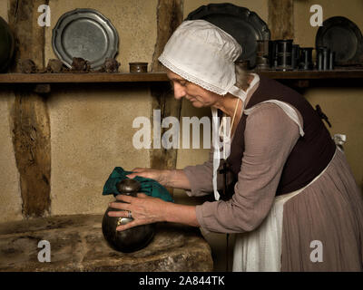 Donna vestita come un contadino medievale cameriera lavora in una cucina autentica in un castello francese Foto Stock