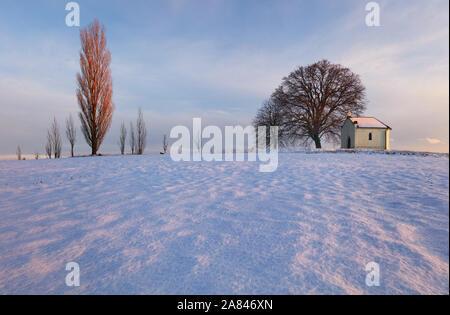 Paesaggio invernale con una bella cappella Foto Stock