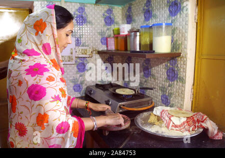 La principessa in cucina - Membro del Parlamento e Jaipur Princess Diya Kumari cibi cotti a un abitante di un villaggio di cucina durante una visita a Beawar, Rajasthan. Foto Stock