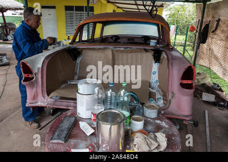 Un cubano auto carrozziere, lavorando su un auto classica in un piccolo villaggio garage nella Valle de Vinales, Pinar del Río Provincia, west Cuba, Cuba Foto Stock