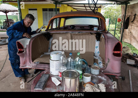 Un cubano auto carrozziere, lavorando su un auto classica in un piccolo villaggio garage nella Valle de Vinales, Pinar del R'o provincia, west Cuba, Cuba Foto Stock
