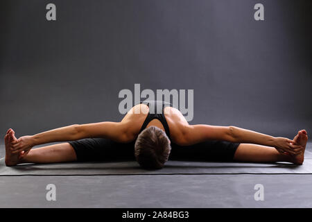 Ragazza stretching. donna pratica yoga upavistha konasana o seduti ampio angolo rappresentano per la meditazione. Upavishtha, cavallo, dragonfly yoga postura. Foto Stock