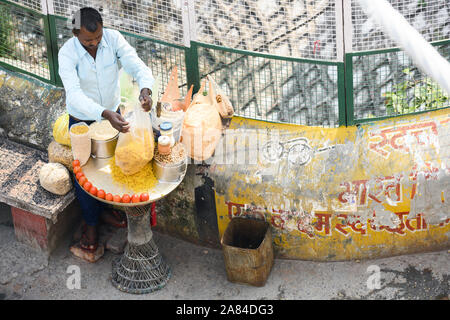 Un venditore ambulante vende spuntini Bhelpuri tra le strette strade di Rishikesh, India. Foto Stock