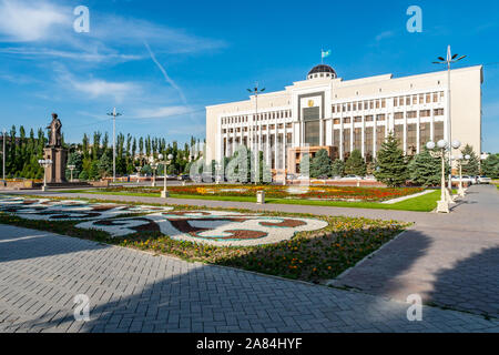 Taraz Akimat regionale Municipio con sventola Bandiera kazaka e la statua di Jambyl Jabayev su un soleggiato Blue Sky giorno Foto Stock