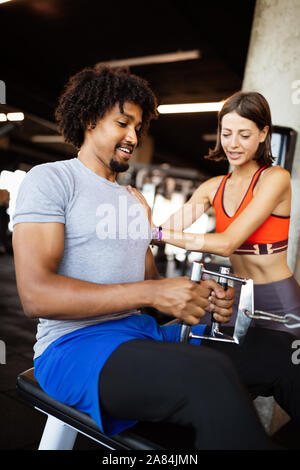 Istruttore di Fitness esercizio con client presso la palestra. Foto Stock