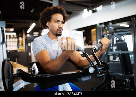 Fitness, sport, esercizio e stile di vita concep giovane uomo che lavora in palestra Foto Stock