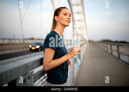 Ritratto di montare e sportività giovane donna jogging all'aperto Foto Stock
